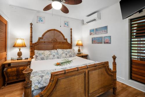 a bedroom with a large wooden bed and two lamps at Kiahuna Paradise at Poipu beach, newly remodeled in Koloa