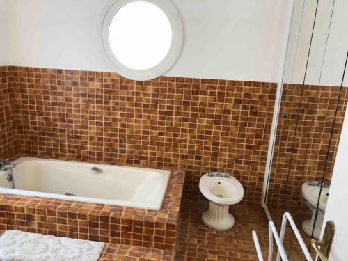 une salle de bain avec une baignoire, des toilettes et un lavabo dans l'établissement VILLA TOUQUETTOISE HELAND , 4 Étoiles , piscine chauffée, à Le Touquet-Paris-Plage