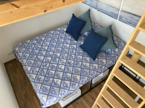 een klein bed in een kleine kamer met blauwe kussens bij "b&b CIUSCIACABBOLA" NOTO - Tiny House in Noto