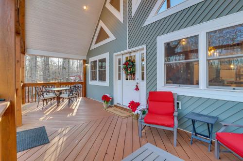 a porch with a red chair and a table at 1 Mi to Beach Pocono Lake Chalet with Decks in Pocono Lake