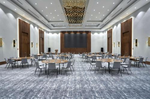 een conferentieruimte met tafels en stoelen en een scherm bij Radisson Hotel Baku in Baku