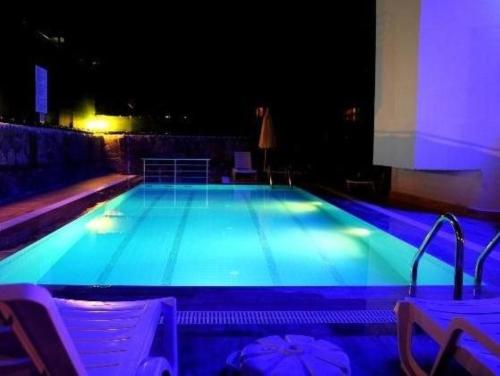 a large swimming pool at night with blue lights at Cleopatra City Hotel in Alanya