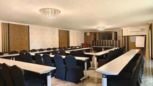 利隆圭Annavilla7 Lilongwe hotel的一间会议室,配有桌椅和吊灯