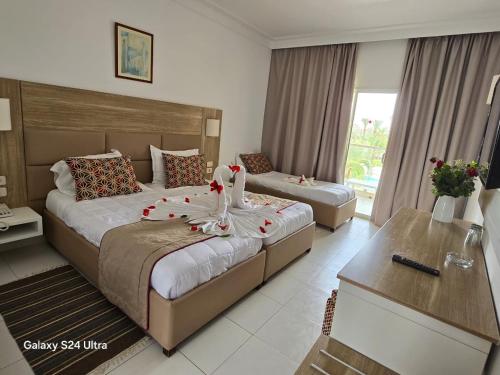 a hotel room with two beds with flowers on them at Palm Beach Club Marmara Skanes in Monastir