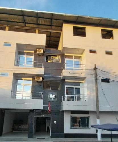 an apartment building with a clock on the side of it at Hospedaje Moralillos in Yurimaguas