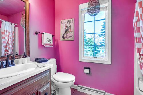 a pink bathroom with a toilet and a sink at Menasha Home with Patio - Walking Distance to Lake! in Menasha