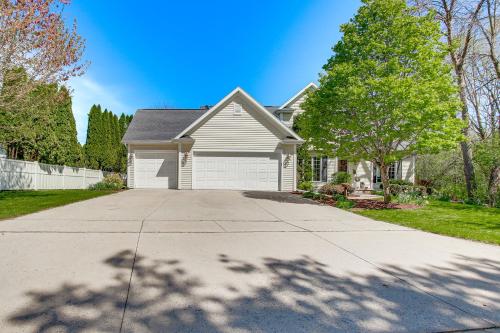 a white house with a driveway and a tree at Menasha Home with Patio - Walking Distance to Lake! in Menasha
