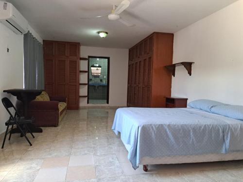 1 dormitorio con cama, escritorio y piano en Aurora, en Cancún