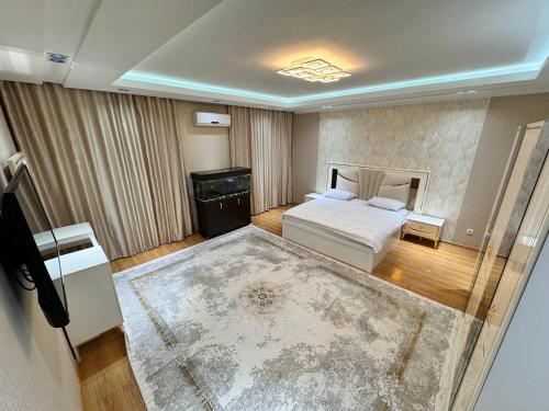 an aerial view of a bedroom with a bed and a rug at Poytakht 80 Apartments in Dushanbe
