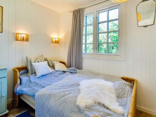 Un dormitorio con una cama con un perro blanco. en Holiday home Vejby XXXVIII en Vejby