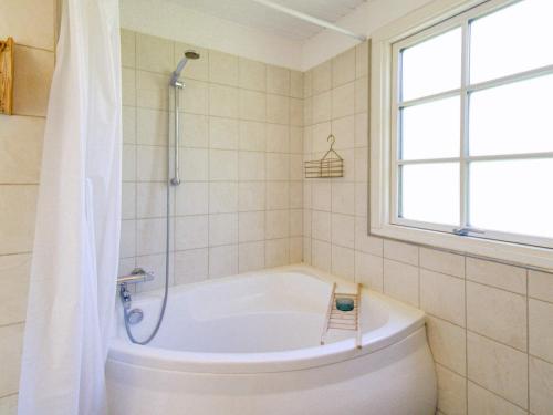 baño con bañera blanca y ventana en Holiday home Vejby XXXVIII en Vejby