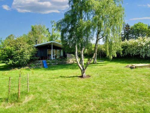 a tree in a yard next to a house at 6 person holiday home in Skibby-By Traum in Skibby