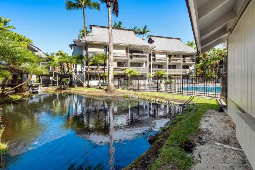 a pool in front of a building with palm trees at Waiakea Villas 4-124 in Hilo