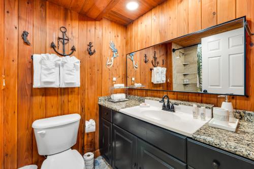 a bathroom with a toilet and a sink and a mirror at Waiakea Villas 4-124 in Hilo