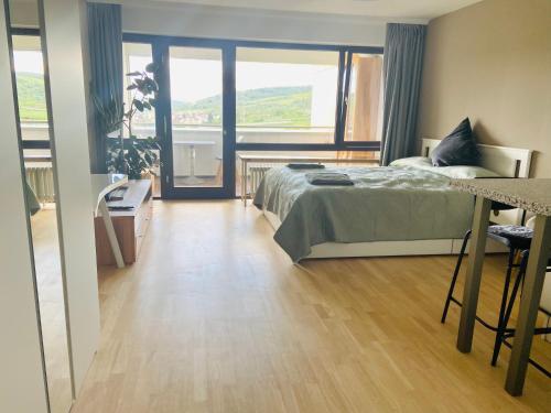 a bedroom with a bed and a large window at Modern Studio apartment - top location in Weinstadt in Weinstadt