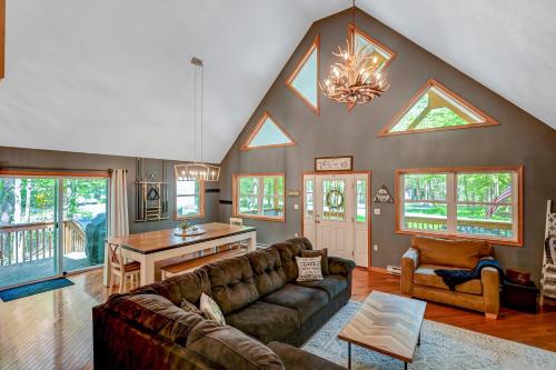 a living room with a couch and a table at 1 Mi to Beach Pocono Lake Chalet with Decks in Pocono Lake