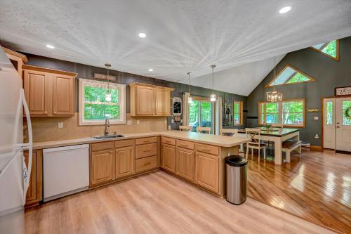 a large kitchen with wooden cabinets and a dining room at 1 Mi to Beach Pocono Lake Chalet with Decks in Pocono Lake