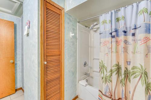 a bathroom with a shower and a shower curtain with palm trees at Lakefront Family Retreat with Private Dock! in Rice Lake