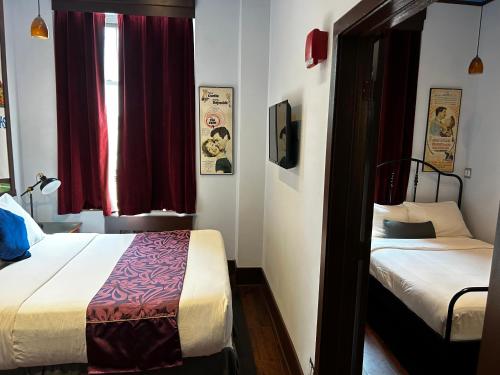 a small bedroom with two beds and a window at Chelsea Pines Inn in New York