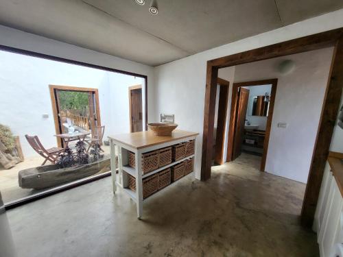 een woonkamer met een tafel en een groot raam bij Auténtica Casa Rústica Canaria in Puntagorda