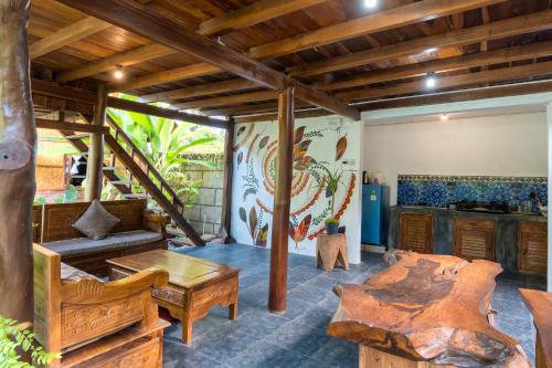 a living room with wooden furniture and a kitchen at Tahlia's Villa in Sorongjukung