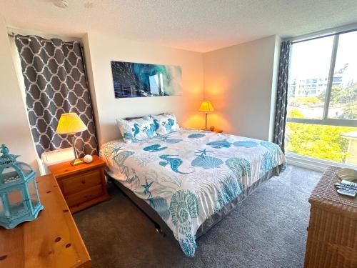um quarto com uma cama e uma grande janela em Oceanview Retreat - Steps to the Beach and 2 Pools em Oceanside