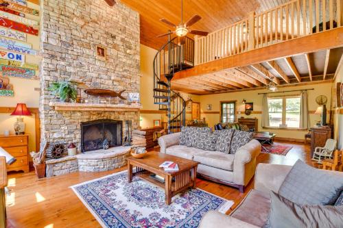 a living room with a stone fireplace at Dog-Friendly Lavonia Home with Dock and Lake Access in Lavonia