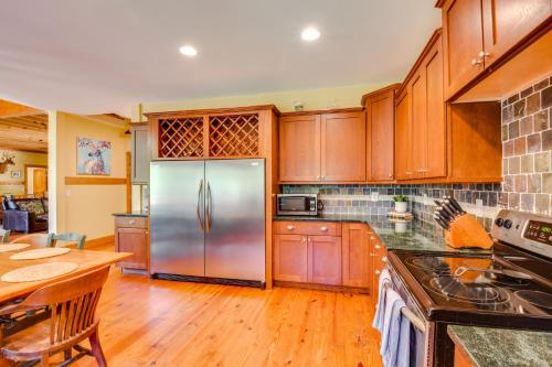 a kitchen with wooden cabinets and a stainless steel refrigerator at Dog-Friendly Lavonia Home with Dock and Lake Access in Lavonia