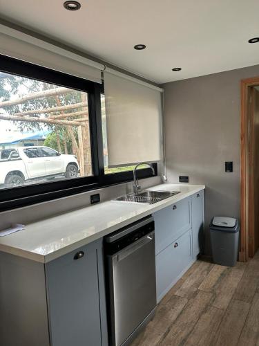 a kitchen with a sink and a window with a car outside at Casa Nera in Chapadmalal