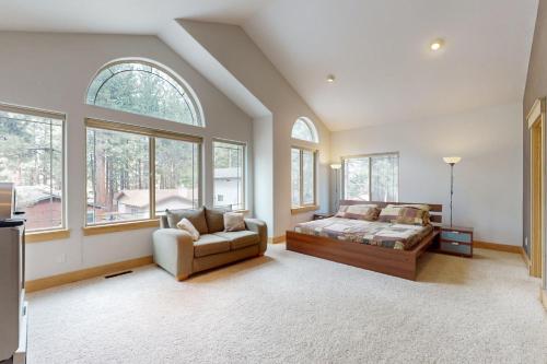 een slaapkamer met een bed, een bank en ramen bij Charles Charmer in South Lake Tahoe