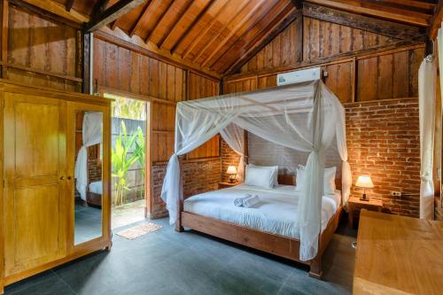 - une chambre avec un lit à baldaquin dans l'établissement Tahlia's Villa, à Sorongjukung