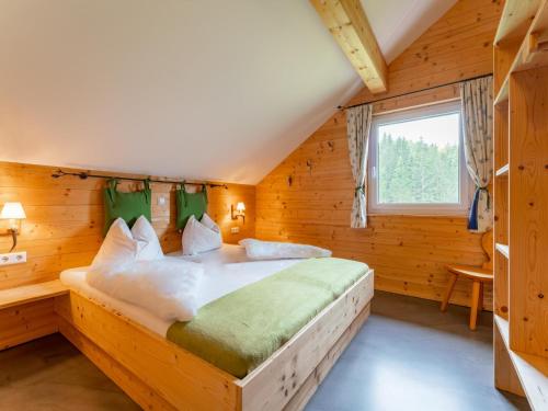 ein Schlafzimmer mit einem großen Bett in einem Holzzimmer in der Unterkunft Moarhof in Hohentauern