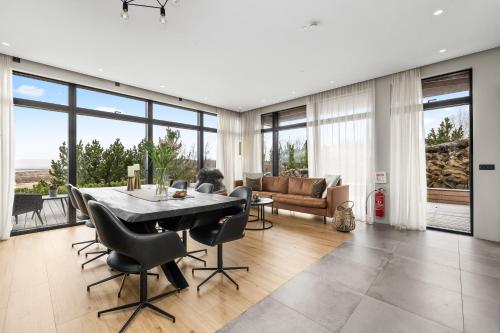 a living room with a table and chairs and a couch at Spacious 4BR Summerhouse With Hot Tub in Reykholt