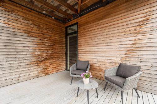two chairs and a table on a wooden patio at Spacious 4BR Summerhouse With Hot Tub in Reykholt