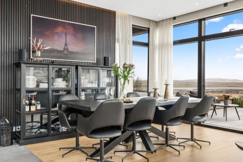 a dining room with a table and chairs at Spacious 4BR Summerhouse With Hot Tub in Reykholt