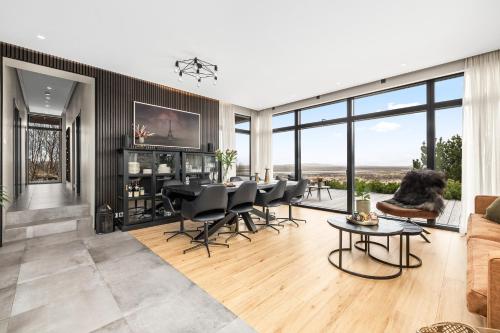 a living room with a dining table and chairs at Spacious 4BR Summerhouse With Hot Tub in Reykholt