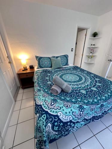 Southwinds Inn by The Gold Nests في هوليوود: غرفة نوم بسرير وبطانية زرقاء وبيضاء