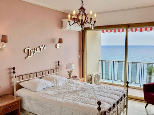 une chambre avec un lit avec vue sur l'océan dans l'établissement T4 FRONT DE MER ,PISCINE 25 metres ,WIFI,6à8 PERSONNES,parking,GARAGE, à Roquebrune-Cap-Martin