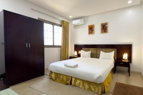 sypialnia z dużym białym łóżkiem i oknem w obiekcie Oasis, Seaside w mieście Dakar