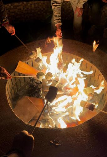 a group of people standing around a fire pit at Aqua Forest Hotel in Cañada