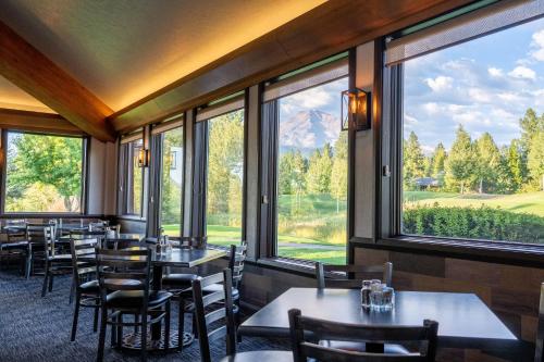 a restaurant with tables and chairs and large windows at Mount Shasta Resort in Mount Shasta