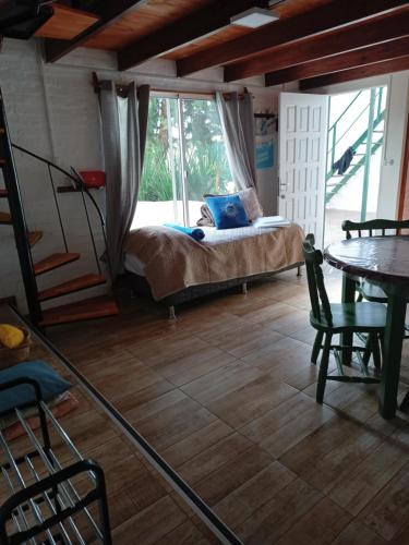 1 dormitorio con cama, mesa y ventana en Departamento para cinco, full equipado, en Colonia del Sacramento