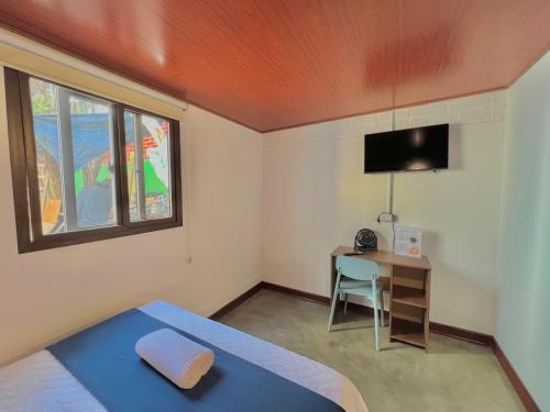 1 dormitorio con cama, escritorio y ventana en Hotel Citadin Z10, en Guatemala