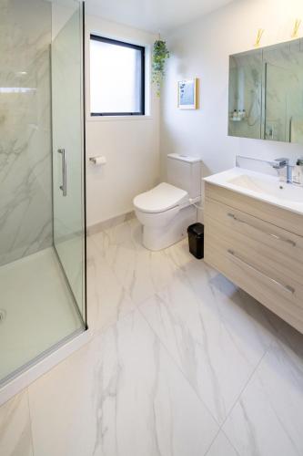 a bathroom with a toilet and a shower and a sink at Serene Living 2 bed with Carpark in Christchurch
