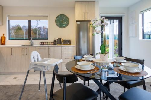 a dining room with a table and chairs and a kitchen at Serene Living 2 bed with Carpark in Christchurch