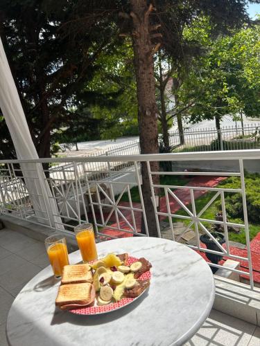 a plate of food on a table with orange juice at Villa in Ptolemaida 