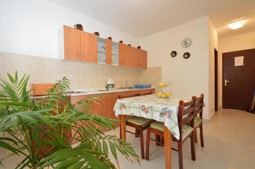 a kitchen with a table and some chairs and a table and a counter at Apartments by the sea Mali Losinj (Losinj) - 14844 in Mali Lošinj