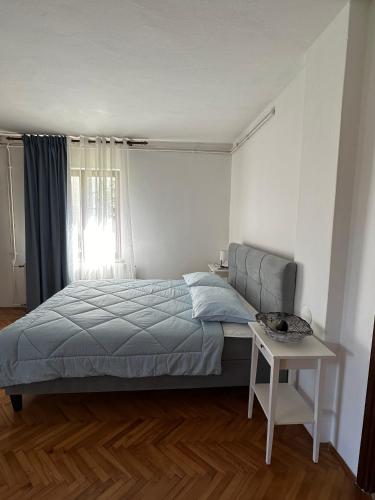 a bedroom with a bed and a table and a window at Apartments by the sea Mali Losinj (Losinj) - 14844 in Mali Lošinj