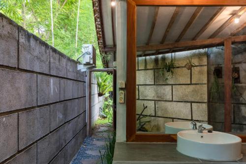 y baño con lavabo y espejo. en Tahlia's Villa en Sorongjukung