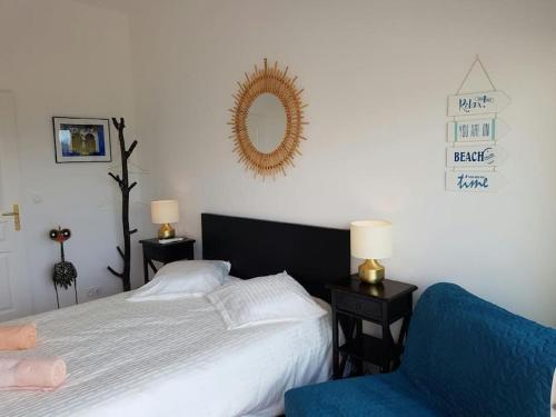 une chambre avec un lit et une chaise bleue dans l'établissement VILLA 4 Étoiles , L'ESCALE ,MERà200m, Les ISSAMBRES ,été du Samedi au Samedi, à Saint-Peïre-sur-Mer